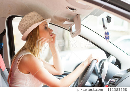 Distracted woman driving her car looking in mirror 111385368