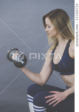 Fit woman lifting dumbbells weights 111385714