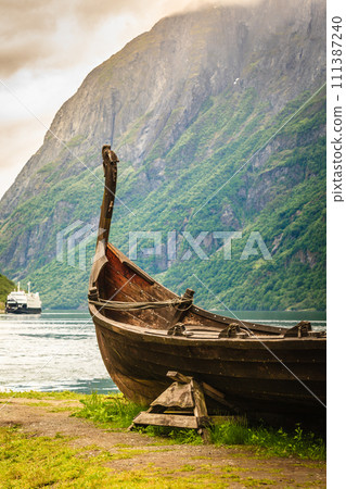 Old viking boat and ferryboat in norwegian fjord 111387240