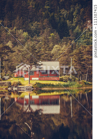 wooden cabin in forest on lake shore, Norway wooden cabin in forest on lake shore, Norway 111387415