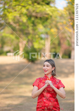 Asian woman in red cheongsam qipao dress holding lantern while visiting the Chinese Buddhist temple during lunar new year for traditional culture 111387828