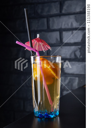 Alcoholic cocktail with orange slices in a blue glass 111388198