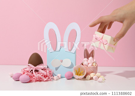 Blue gift box with rabbit ears and chocolate eggs Blue gift box with rabbit ears and chocolate eggs 111388602