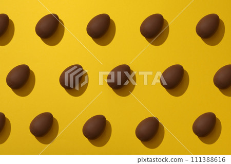 Delicious chocolate egg on a yellow background Delicious chocolate egg on a yellow background 111388616