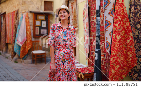 female summer travel to Antalya, Turkey. young asian woman in red dress walk old town Kalechi , female tourist traveler discover interesting places and popular tourist attraction, look on capret 111388751