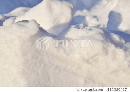 Lumps of snow in winter. Snow and light during the day. Snowdrifts. 111389427