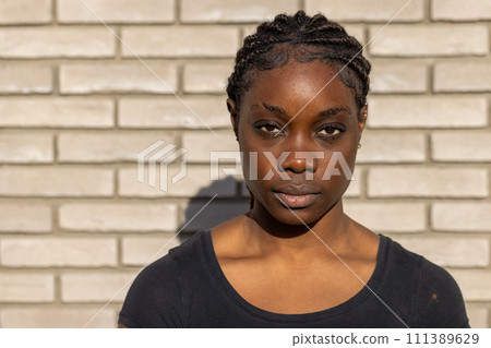 Confident Young Woman Against Brick Wall Confident Young Woman Against Brick Wall 111389629