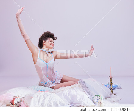 Timeless elegance. Beautiful young woman in tender lingerie, stylish hairstyle and makeup waking up on white bed. Morning aesthetics. Timeless elegance. Beautiful young woman in tender lingerie, stylish hairstyle and makeup waking up on white bed. Morning aesthetics. 111389814