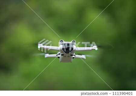 Flying drone with blurred green background. Flying drone with blurred green background. 111390401