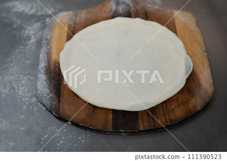 Fresh raw pizza dough on wooden tray Fresh raw pizza dough on wooden tray 111390523