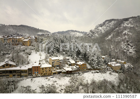 Aerial winter landscape of dense historic center of Thiers town in Puy-de-Dome department, Auvergne-Rhone-Alpes region in France. Rooftops of old buildings and narrow streets at snowfall Aerial winter landscape of dense historic center of Thiers town in Puy-de-Dome department, Auvergne-Rhone-Alpes region in France. Rooftops of old buildings and narrow streets at snowfall 111390587
