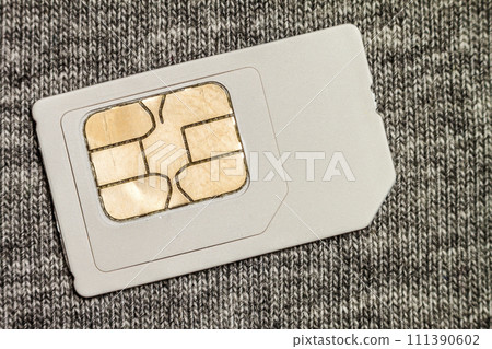 Simcard isolated on grey cloth texture background Simcard isolated on grey cloth texture background 111390602