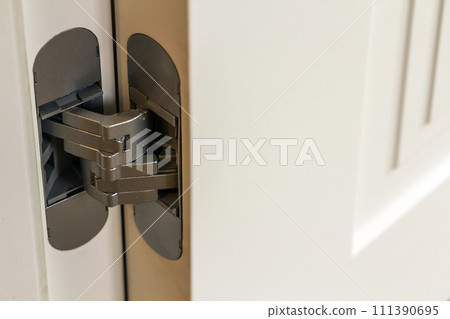 New modern metal door hinges on white wooden doors 111390695