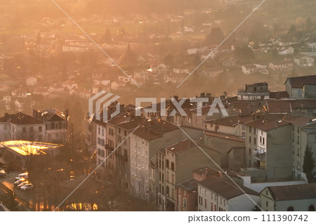 Aerial view of dense historic center of Thiers town in Puy-de-Dome department, Auvergne-Rhone-Alpes region in France. Rooftops of old buildings and narrow streets at sunset 111390742