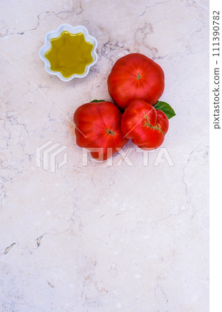 Olive oil and tomatoes on limestone table. Olive oil and tomatoes on limestone table. 111390782