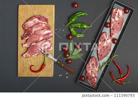 pork meat and vegetables on black background pork meat and vegetables on black background 111390793