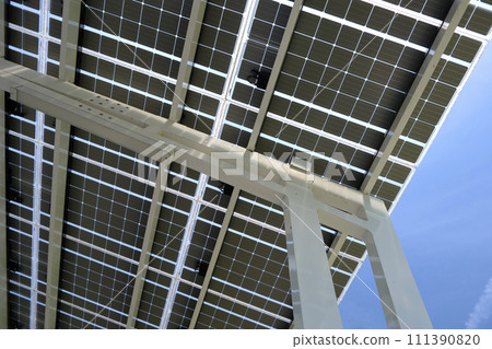 Solar panels installed as shade roof over parking lot for parked electric cars for effective generation of clean electricity. Photovoltaic technology integrated in urban infrastructure Solar panels installed as shade roof over parking lot for parked electric cars for effective generation of clean electricity. Photovoltaic technology integrated in urban infrastructure 111390820