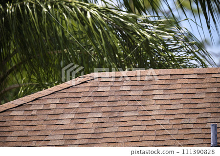 Closeup of house roof top covered with asphalt or bitumen shingles. Waterproofing of new building 111390828