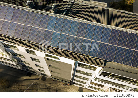 Aerial view of solar photovoltaic panels on a roof top of residential building block for producing clean electric energy. Autonomous housing concept. 111390875