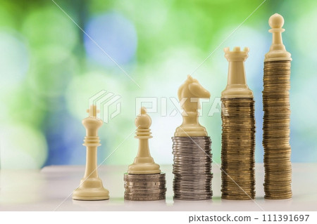 Growing coins stacks green bokeh background. Chess figures standing on coins meaning power and career growth. Financial growth, saving money, business finance wealth and success concept. Growing coins stacks green bokeh background. Chess figures standing on coins meaning power and career growth. Financial growth, saving money, business finance wealth and success concept. 111391697
