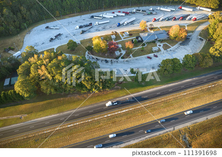 Top view of large rest area near busy multilane american freeway with fast moving cars and trucks. Recreational resting place during interstate traveling 111391698