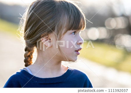 Portrait of a pretty child girl outdoors on a sunny warm autumn day. 111392037