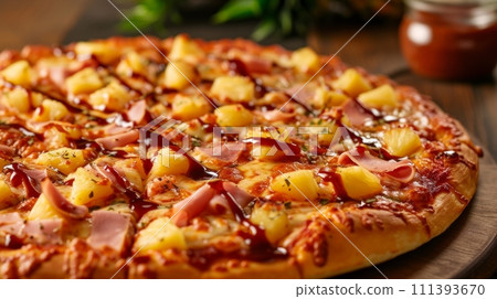 A Hawaiian pizza with pineapple, ham, and a drizzle of sweet barbecue sauce 111393670