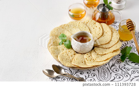 Moroccan breakfast with Baghrir, mint tea and honey 111393728