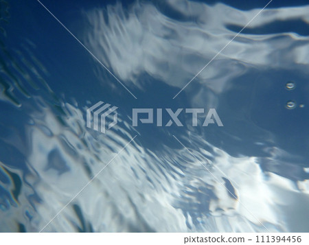 Looking through ocean water at blue sky and clouds with water ripples Looking through ocean water at blue sky and clouds with water ripples 111394456