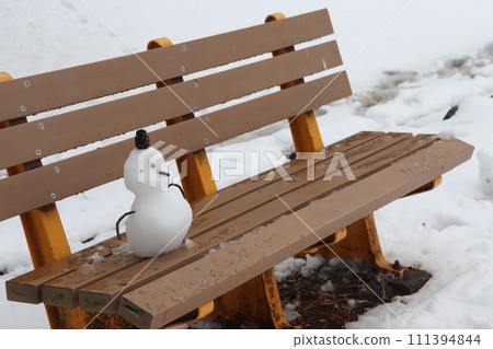 雪人坐在公園的長椅上 111394844