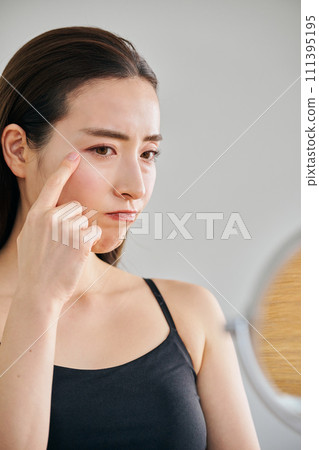30多歲的女性在照鏡子時擔心自己皮膚上有皺紋 30多歲的女性在照鏡子時擔心自己皮膚上有皺紋 111395195