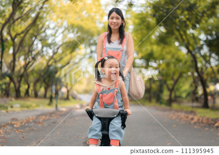 Asian mother walking with daugther in stroller in park,  Happy family concept. 111395945