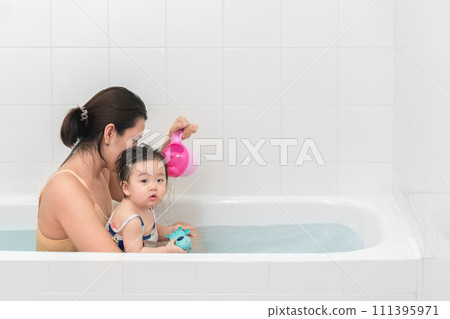 Asian mother and baby girl bathing together in bathtub, Happy lifestyle family concept. 111395971