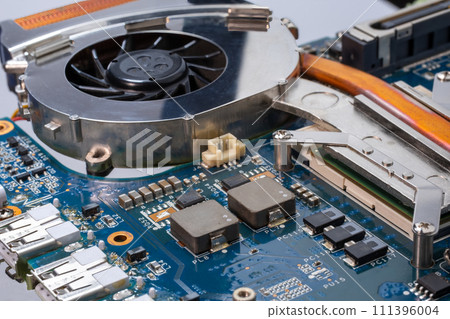 Laptop cooling technology. A detailed shot of a computer motherboard, cooling fan for CPU, chipsets and circuit board showcasing the intricate engineering and composite materials used in its 111396004