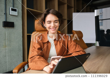 Portrait of woman in office, employee working on project with digital tablet, using device on meeting in conference room 111396029