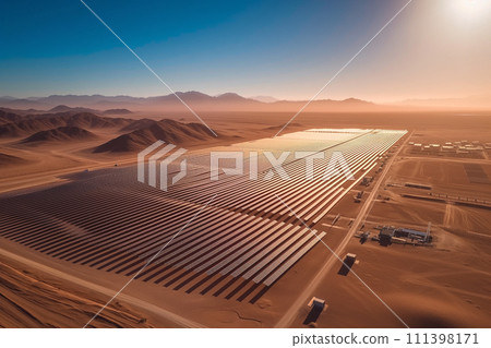 The sun rises, casting a golden glow over an extensive array of solar panels amidst a desert landscape. 111398171