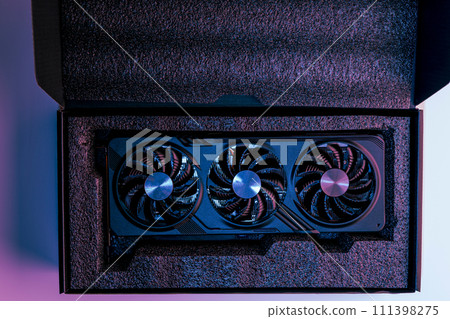 video card for a computer with three fans lies in holders in the shipping box 111398275