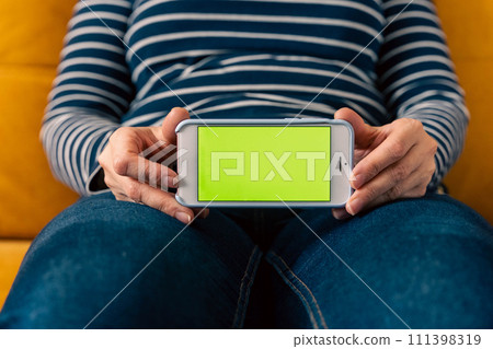 unrecognizable woman holding and showing mobile phone with blank screen mockup 111398319