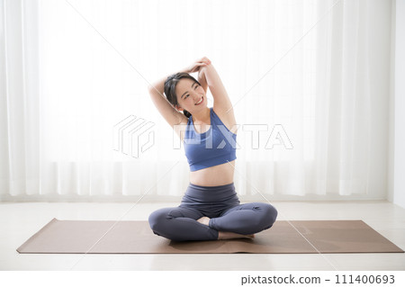 Young woman stretching and doing yoga, wide angle 111400693