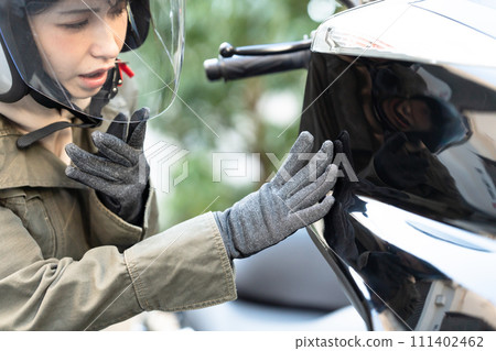檢查摩托車的婦女 檢查摩托車的婦女 111402462