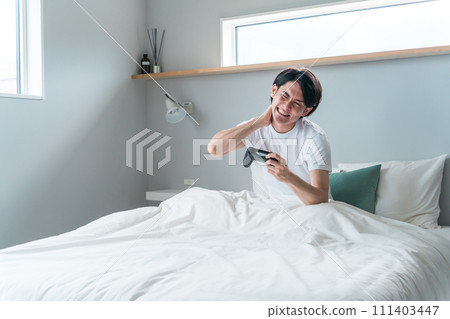 Male gamer playing games in the bedroom at home (losing, frustrating, paying) 111403447