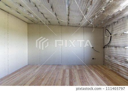 Room under construction with silver aluminum insulation foil and drywall on walls and ceiling. 111403797