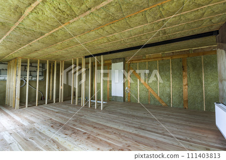 Construction and renovation of big spacious empty unfinished attic room with oak floor, walls and ceiling insulated with rock wool and fiber glass for cold barrier and wooden frame for future walls. Construction and renovation of big spacious empty unfinished attic room with oak floor, walls and ceiling insulated with rock wool and fiber glass for cold barrier and wooden frame for future walls. 111403813