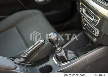 Luxurious car black leather interior. Handbrake manual brake and gearshift stick on blurred background. Transportation, design, modern technology concept. Luxurious car black leather interior. Handbrake manual brake and gearshift stick on blurred background. Transportation, design, modern technology concept. 111403821
