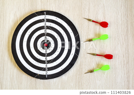 Arrows on target dart on wooden background. Top view. 111403826