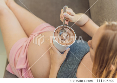 Happy pregnant young woman eating ice cream 111406800