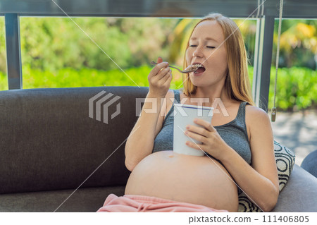 Happy pregnant young woman eating ice cream Happy pregnant young woman eating ice cream 111406805