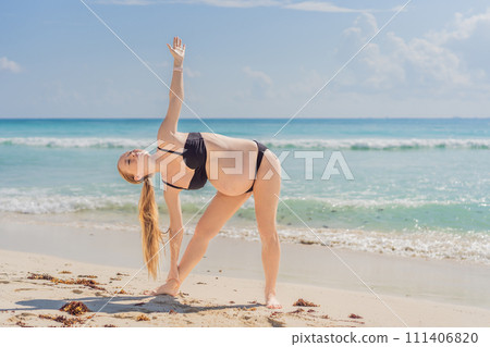 Harmonizing mind and body, a pregnant woman gracefully practices yoga on the beach, embracing the serenity of the seaside for a tranquil and mindful pregnancy experience 111406820