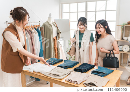 一名婦女和一名店員在服飾店買衣服 111406990