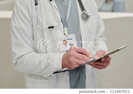 Clinician filling in medical document Clinician filling in medical document 111407021